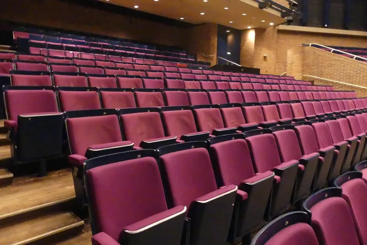 Theater-/Saalbestuhlung, 6 Reihen à 24 Sitzplätze, gepolsterte Klappsitze, pink/schwarz